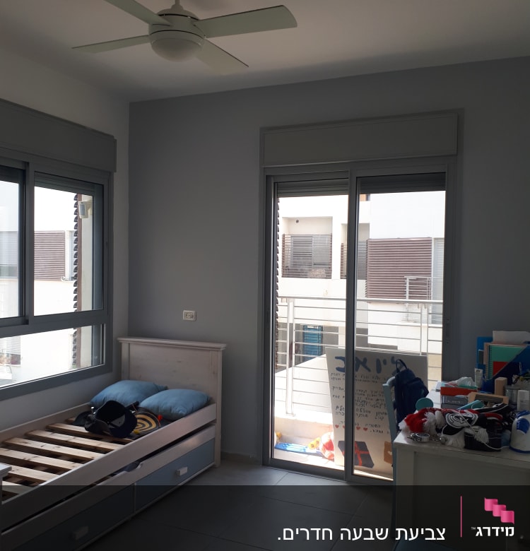 חדר עם מיטה, מאוורר תקרה וחלון גדול